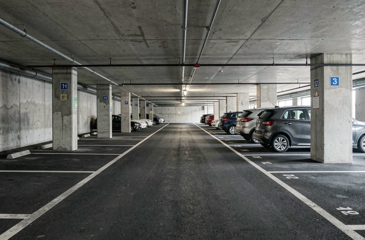 Parking souterrain avec des places de stationnement aux dimensions variées, illustrant la rentabilité locative selon la taille des espaces